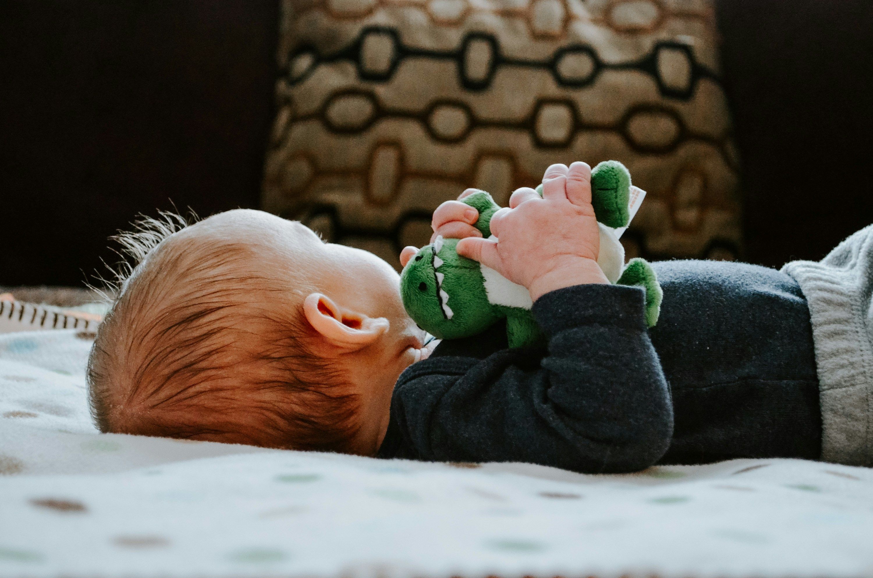 Baby mit Kuscheltier liegend
