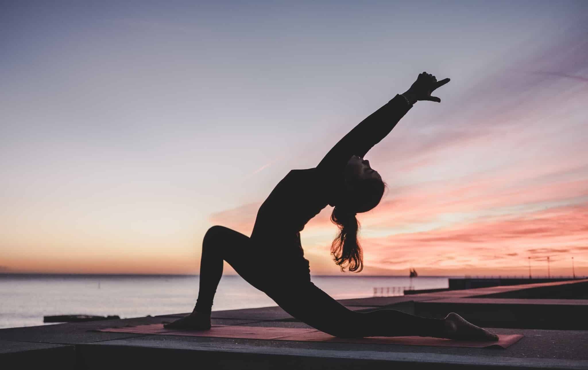 Frau beim Yoga am Meer