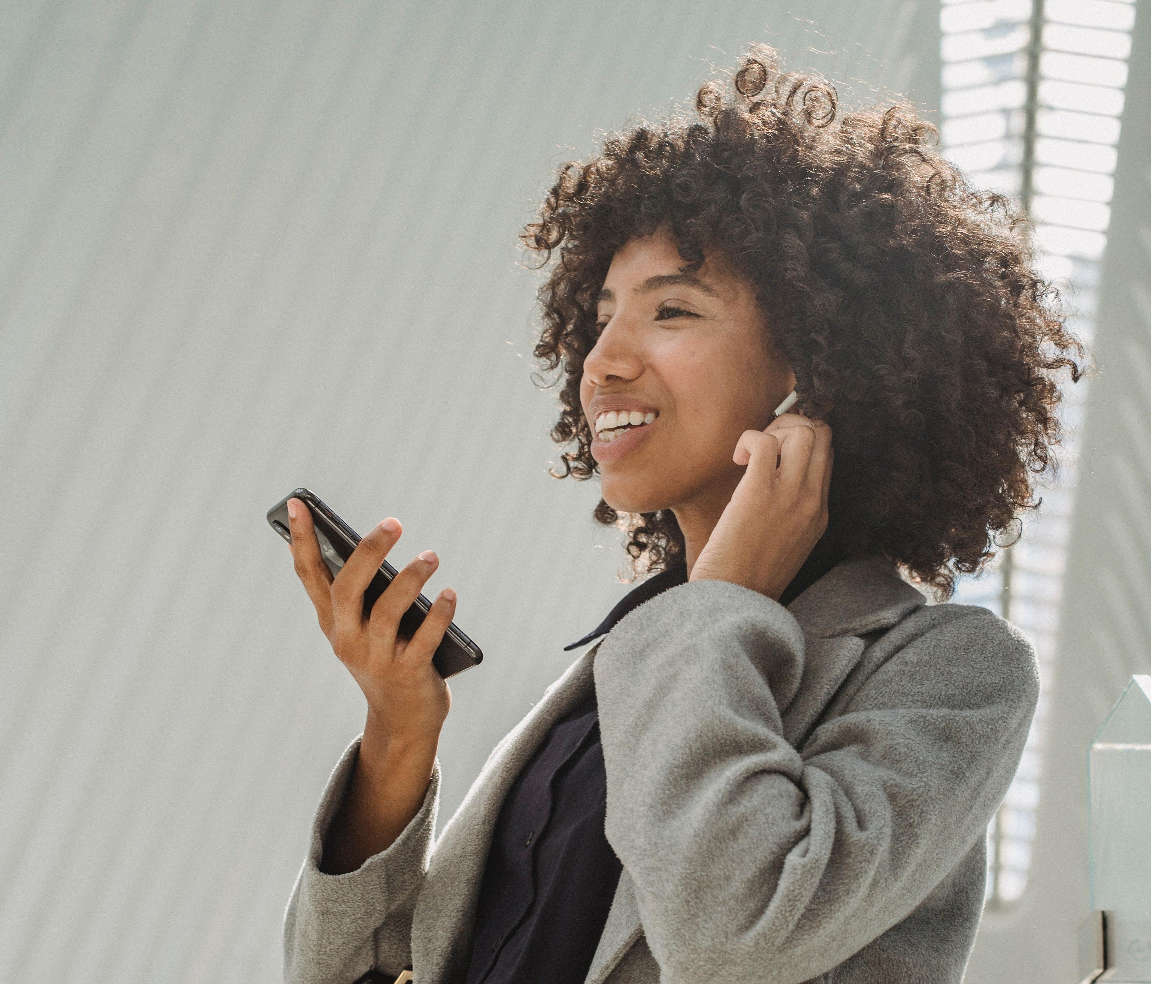 Frau mit In-Ear-Kopfhörer und Smartphone