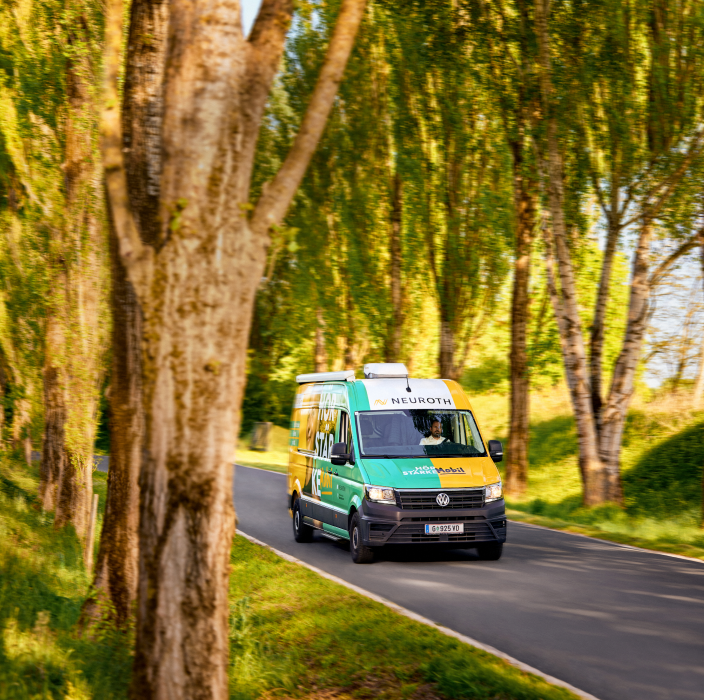 Das Hörmobil fahrend auf einer Waldstraße.