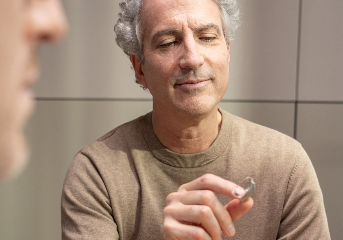 Homme à un appareil auditif dans la main