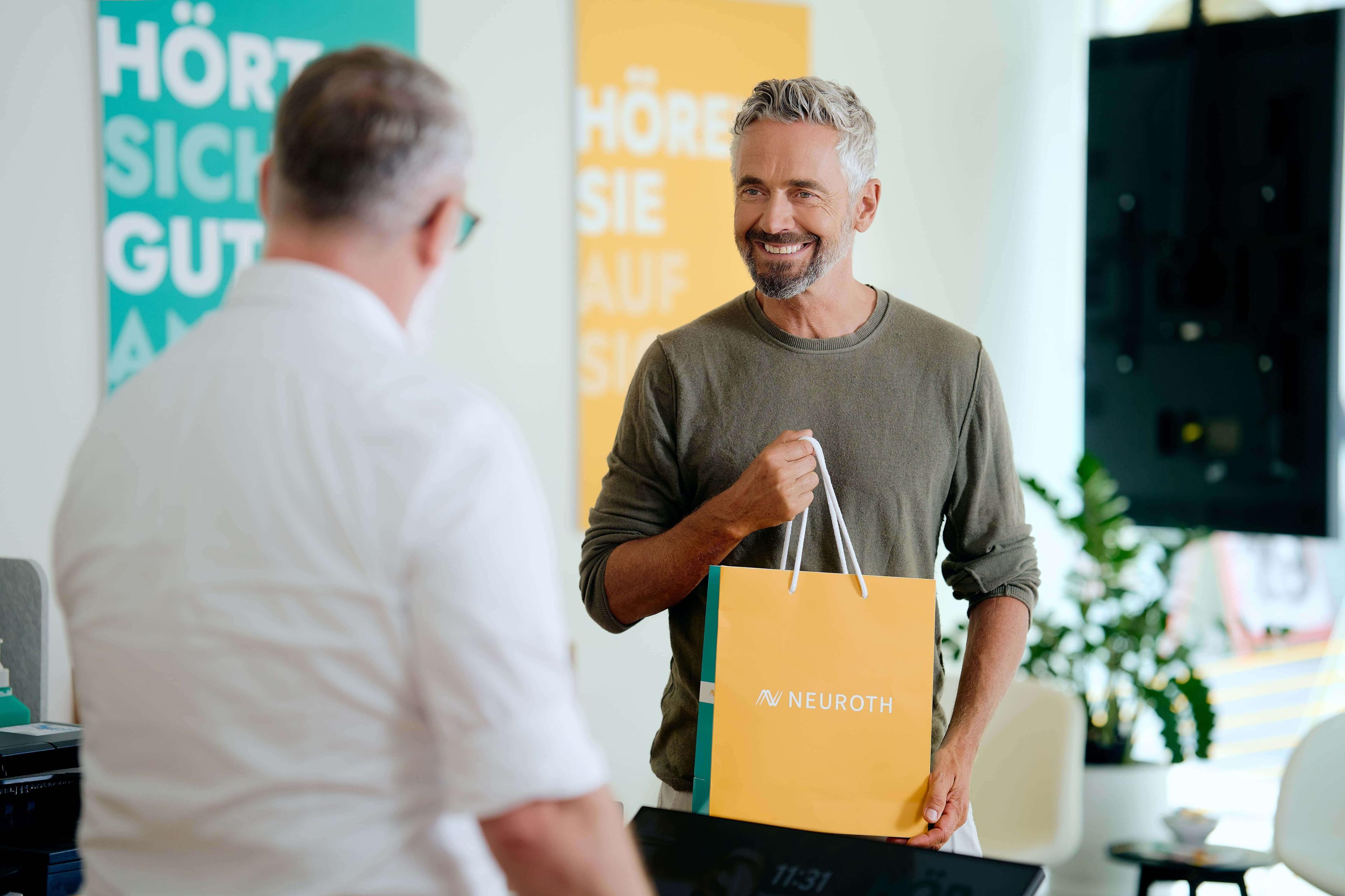 Mann mit Neuroth Tüte in Neuroth Filiale