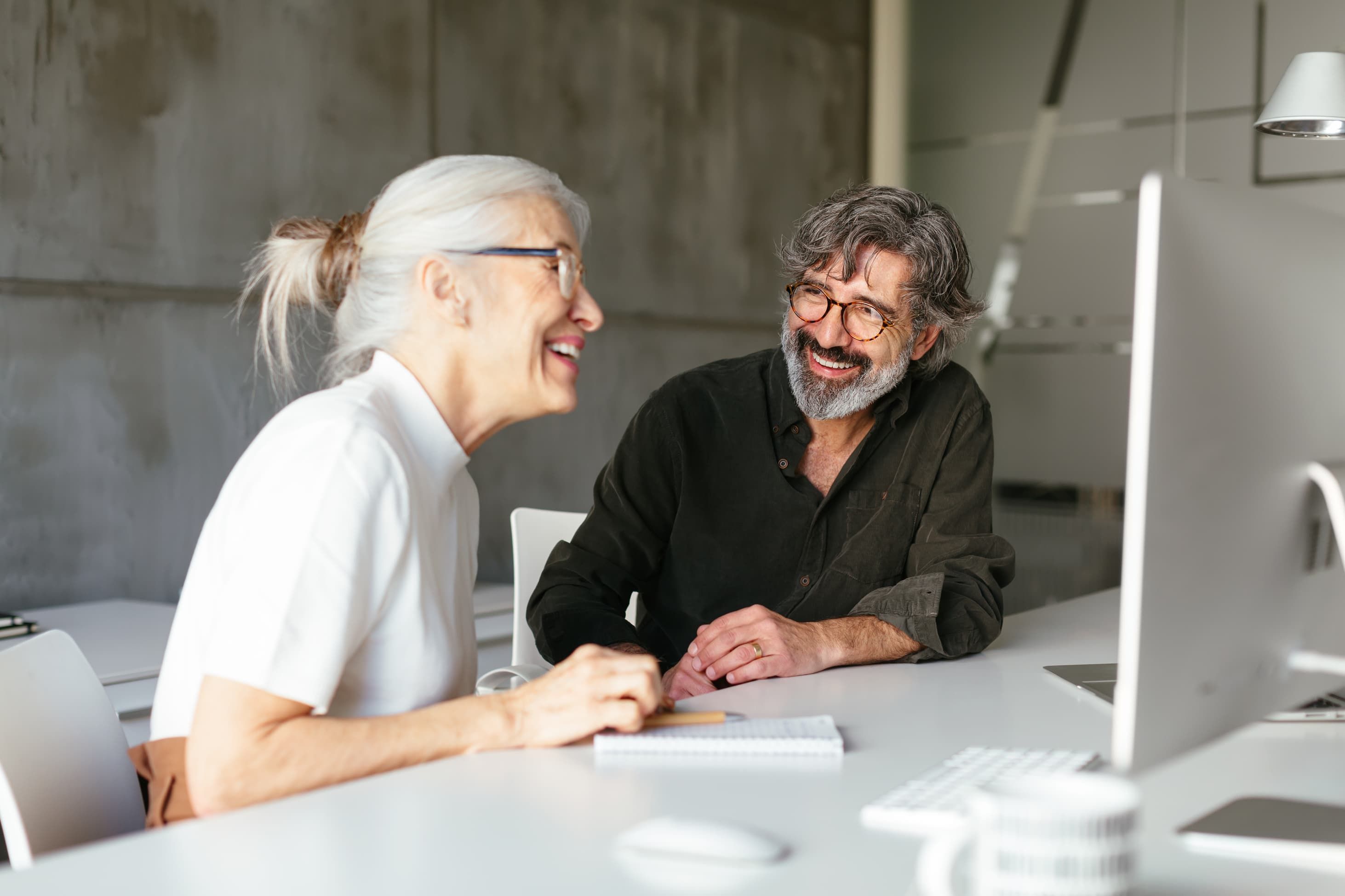 Mann und Frau vor Bildschirm