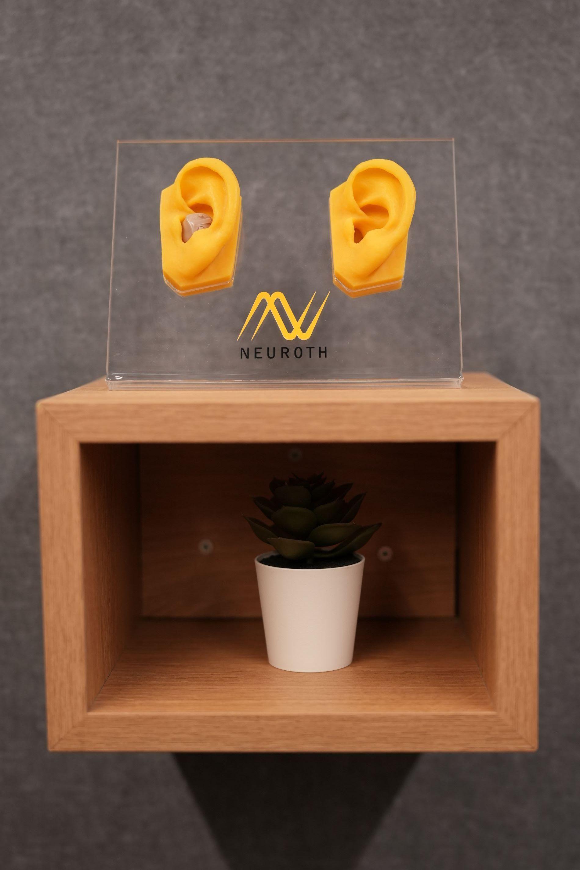 dva plasticna anatomska prikaza ljudskog uha zute boje sa Neuroth logom