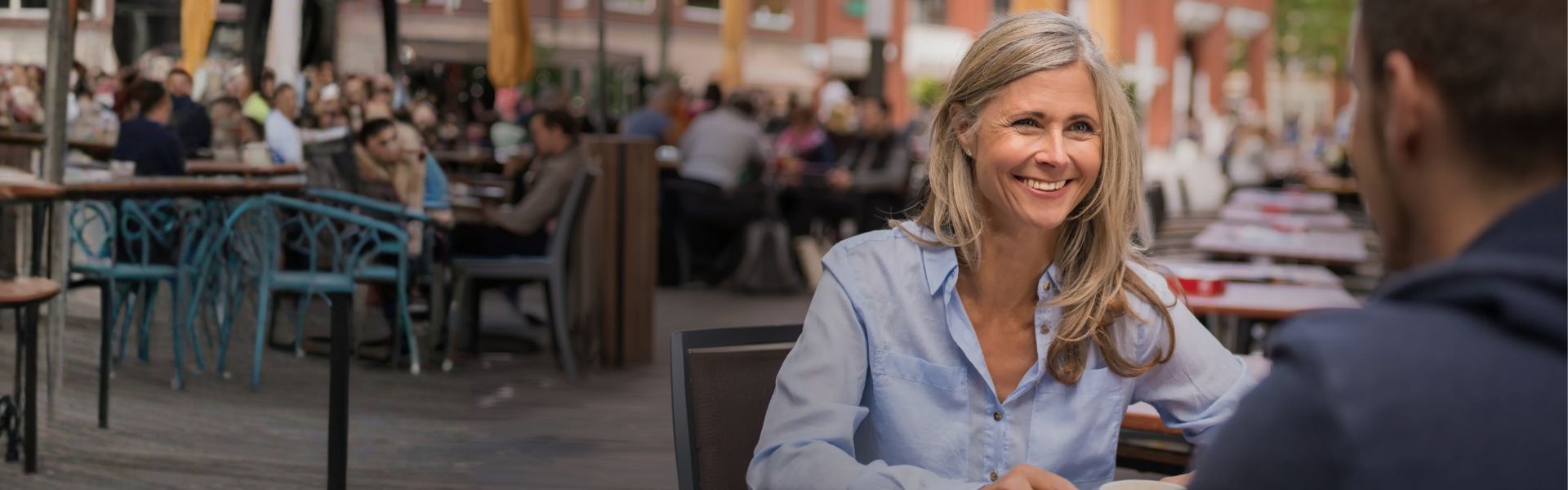 Frau sitzt im Cafe und lacht