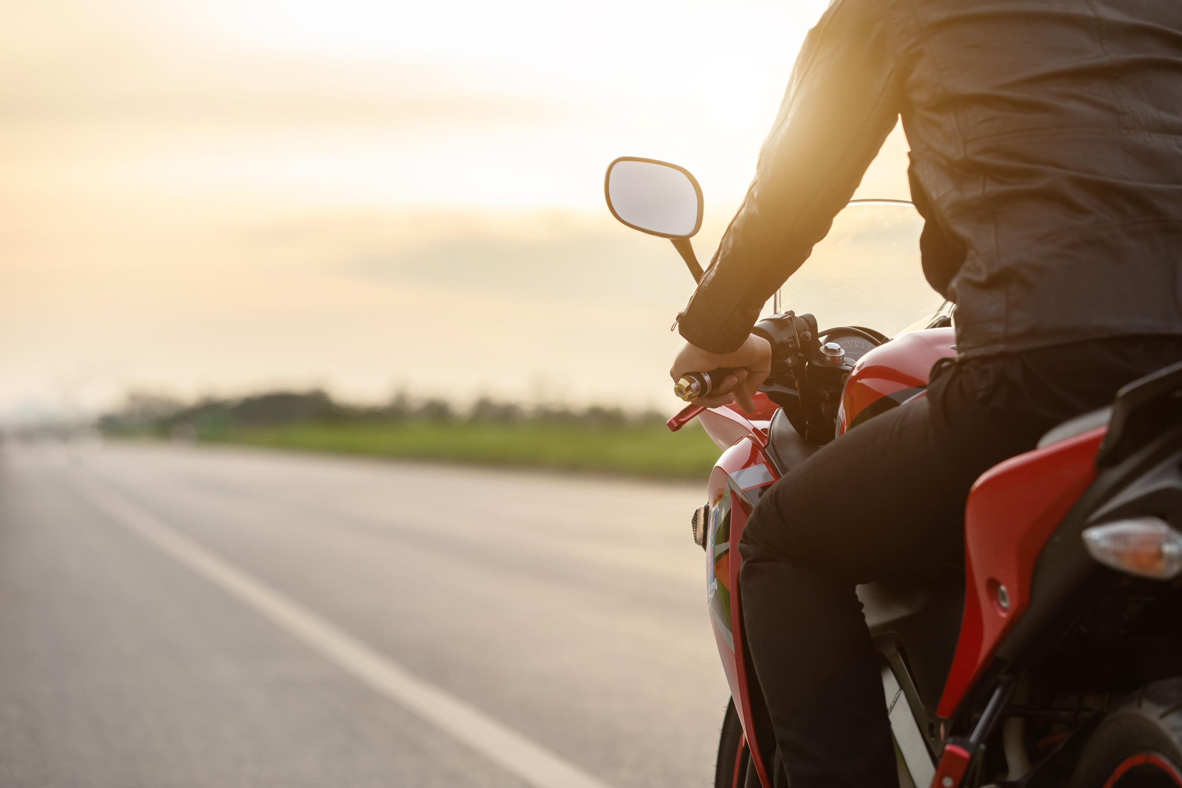 Motorista na motoru na cesti snimljen sa leđa