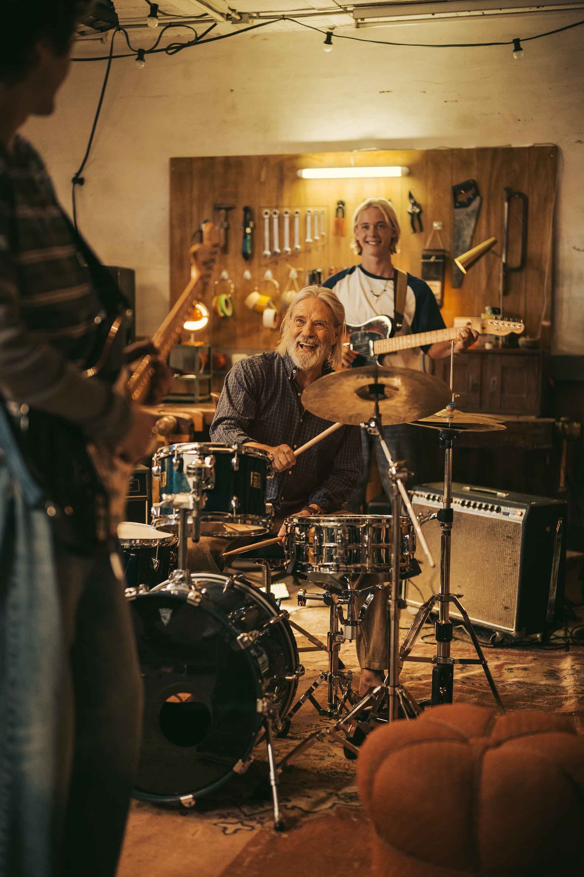 Älterer Mann in Garage am Schlagzeug spielen