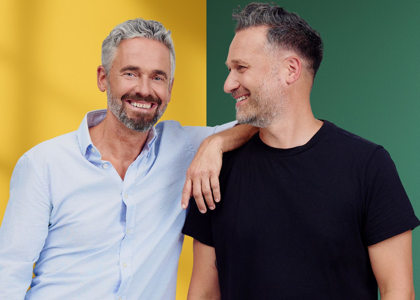 Deux hommes souriants se tiennent côte à côte devant un fond jaune et vert.