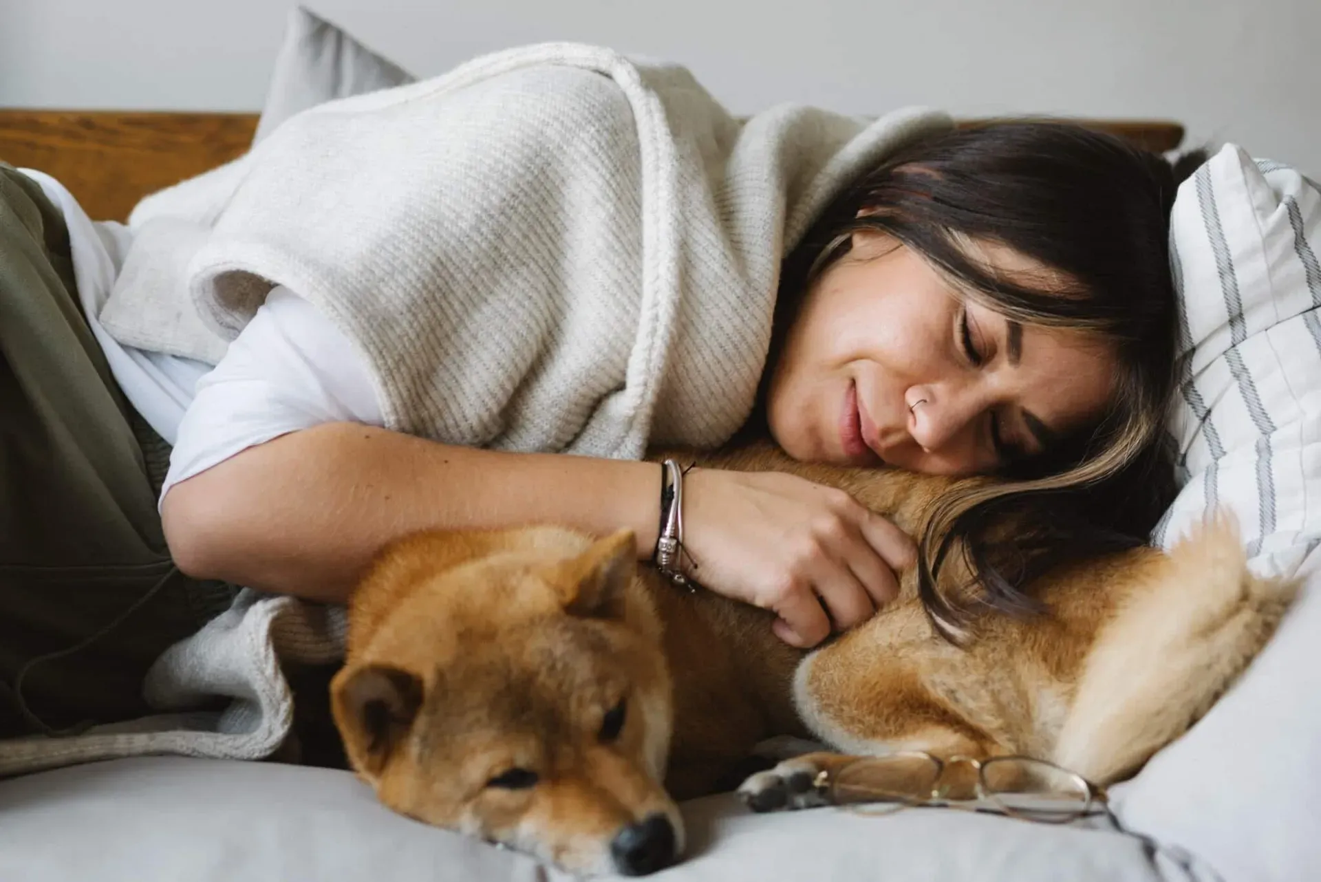 Djevojka spokojno spava pored shiba inu psa