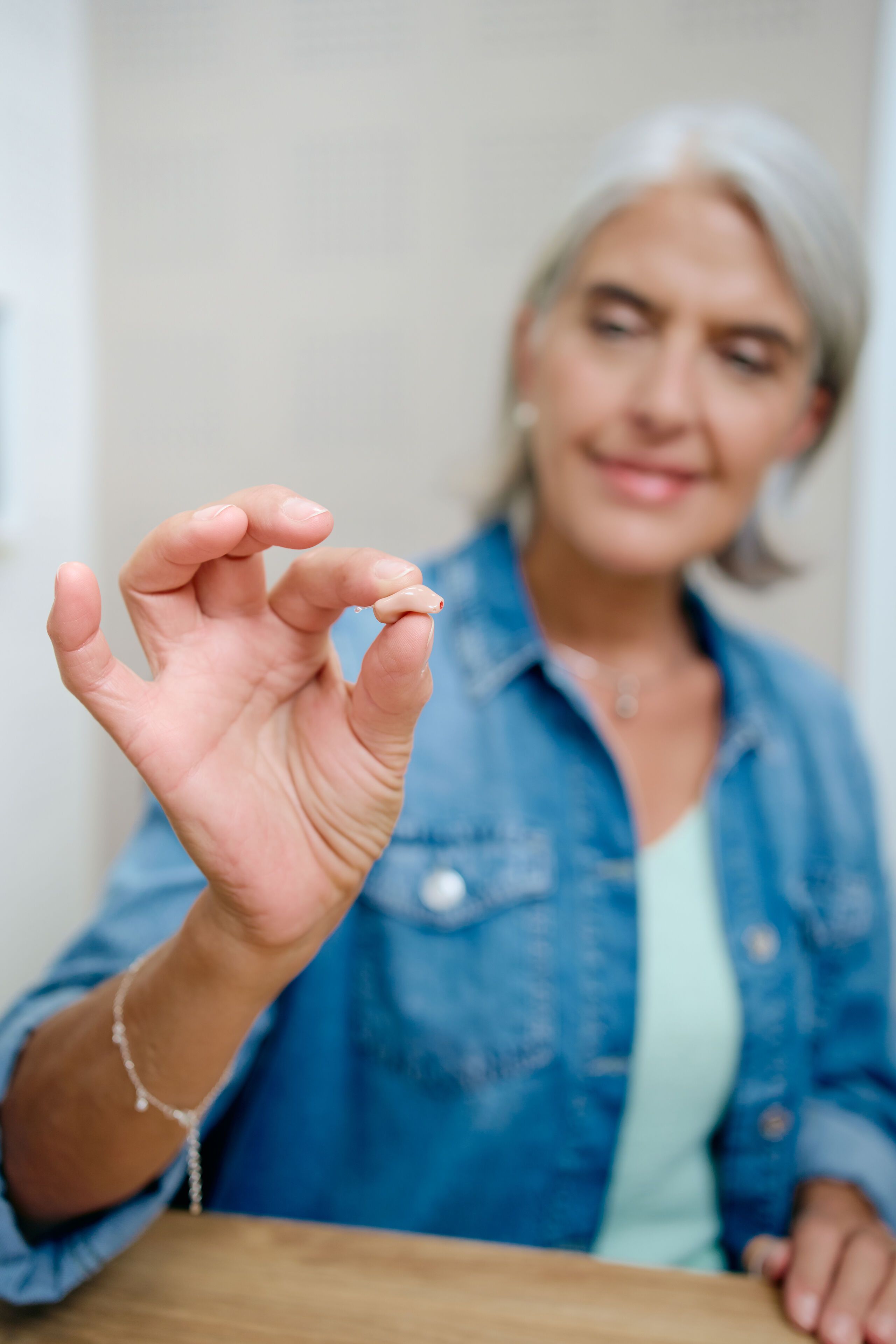 Femme avec appareil auditif dans l oreille et dans la main