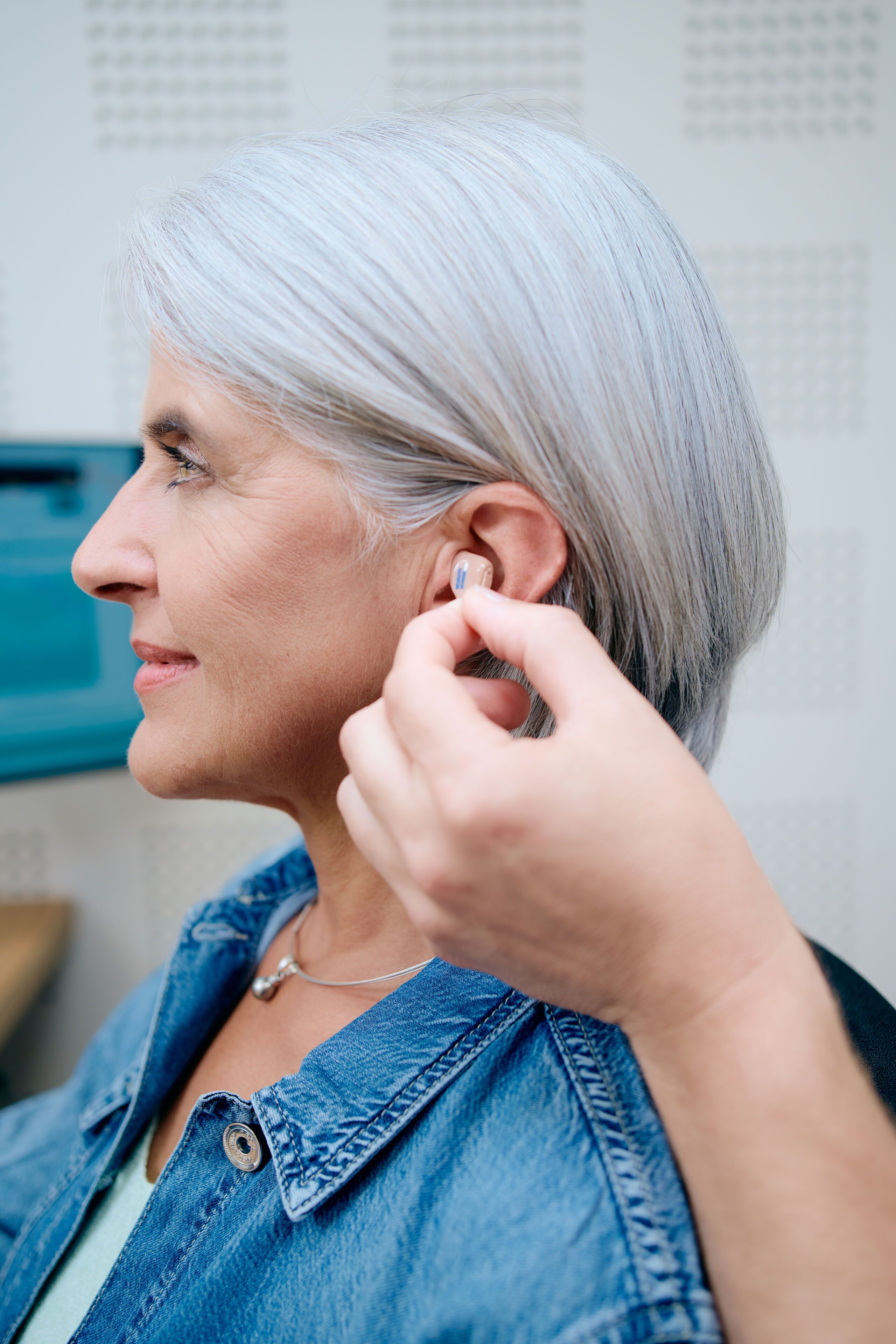 Femme se fait ajuster un appareil auditif dans l'oreille