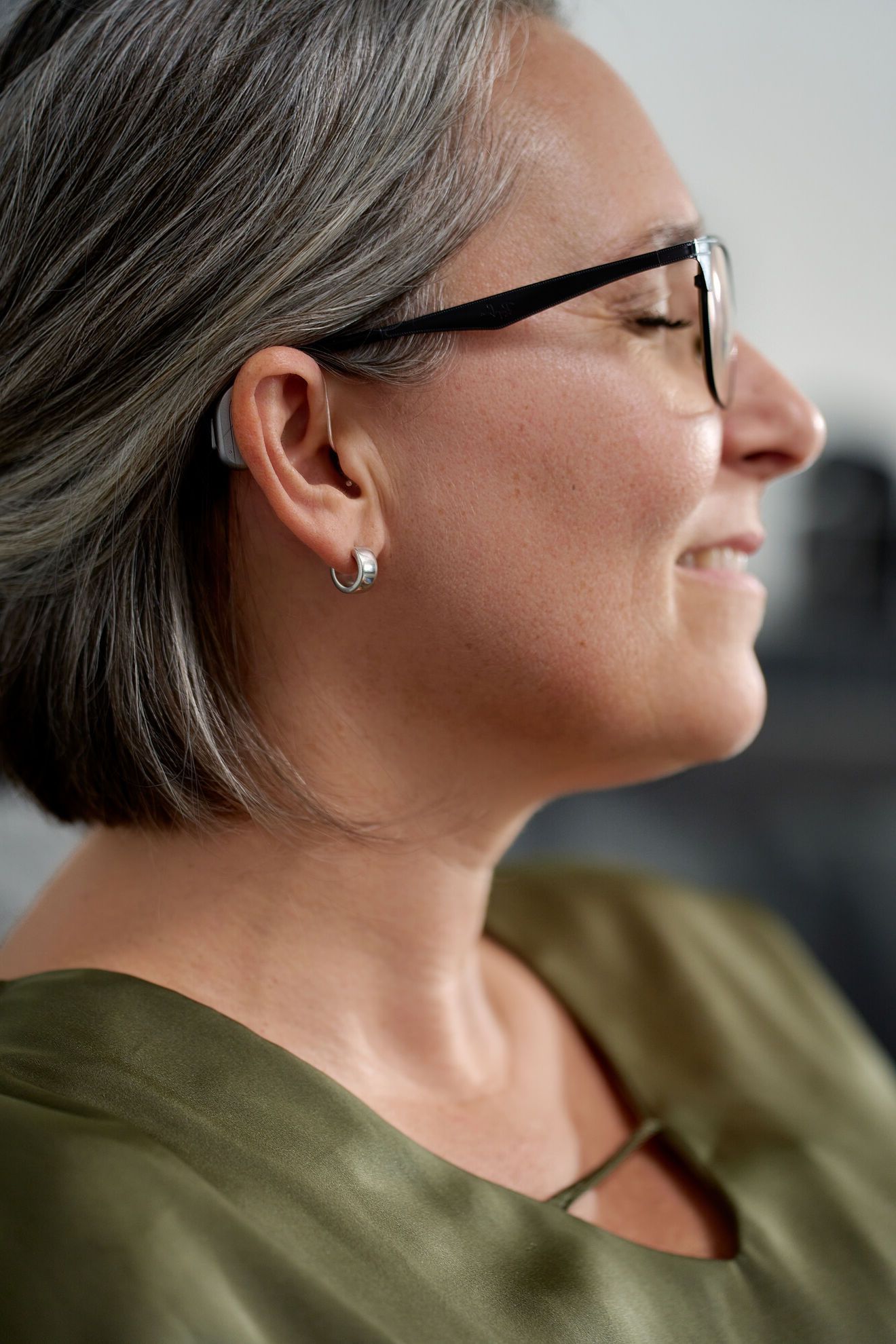 Frau mit Hinter-dem-Ohr-Hörgerät Nahaufnahme