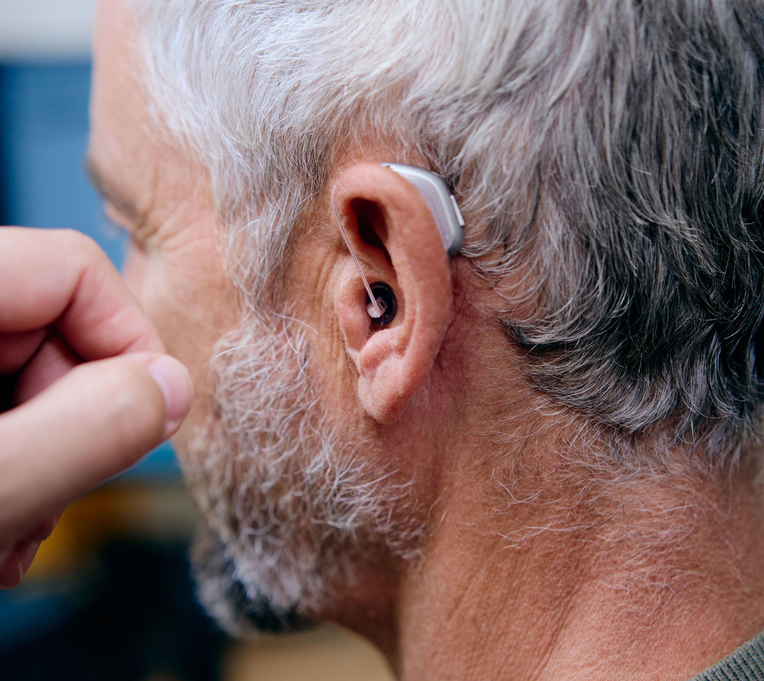 Homme portant un appareil auditif contour d’oreille