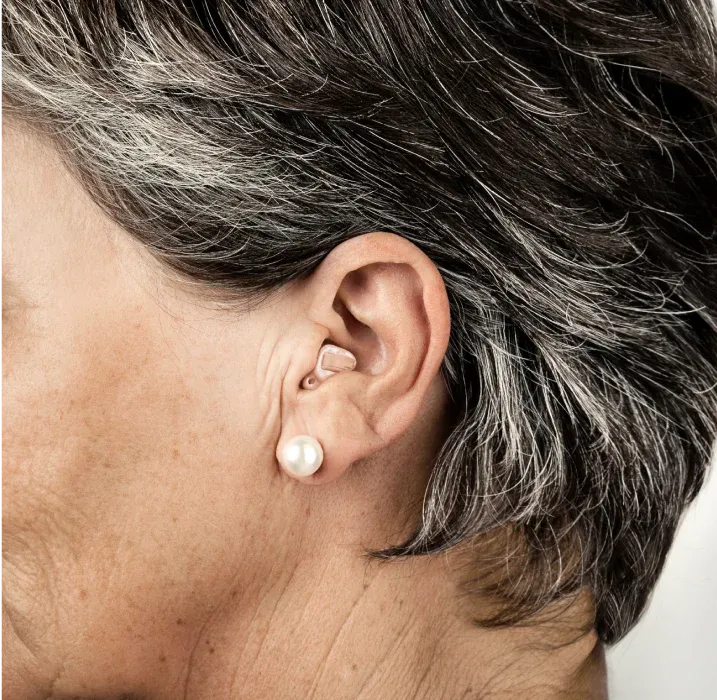 Detaljni prikaz kanalnog slušnog aparata u uhu starije žene