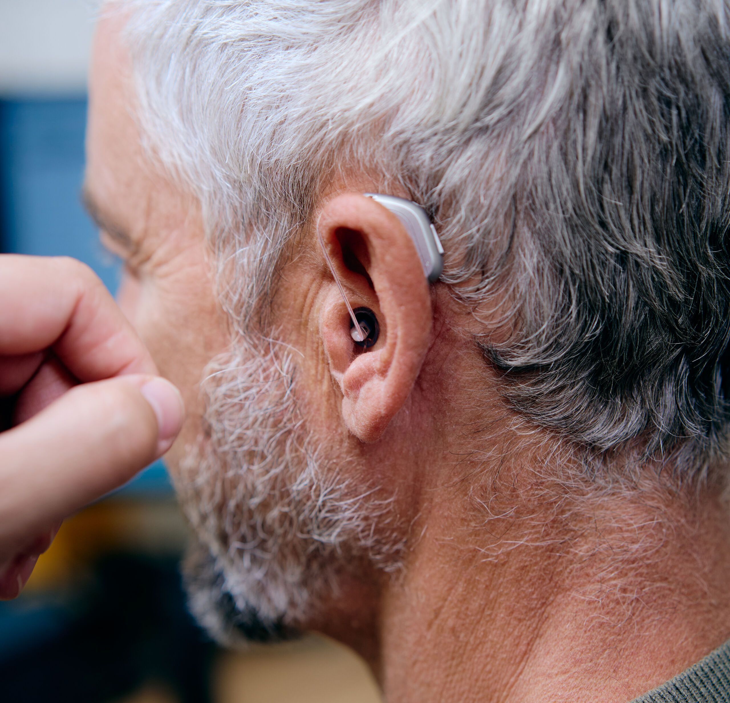 Mann trägt ein Hinter-dem-Ohr-Hörgerät