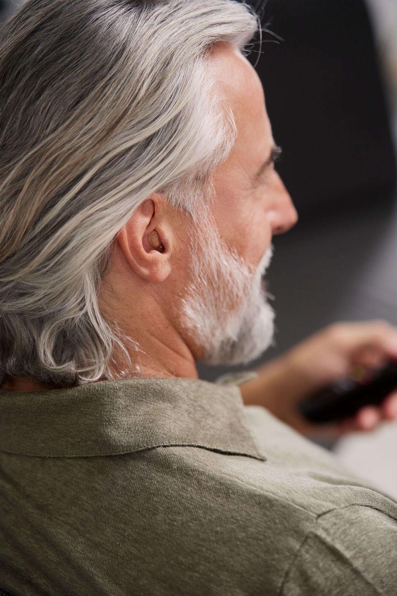 Mann mit Im-Ohr-Hörgerät Nahaufnahme