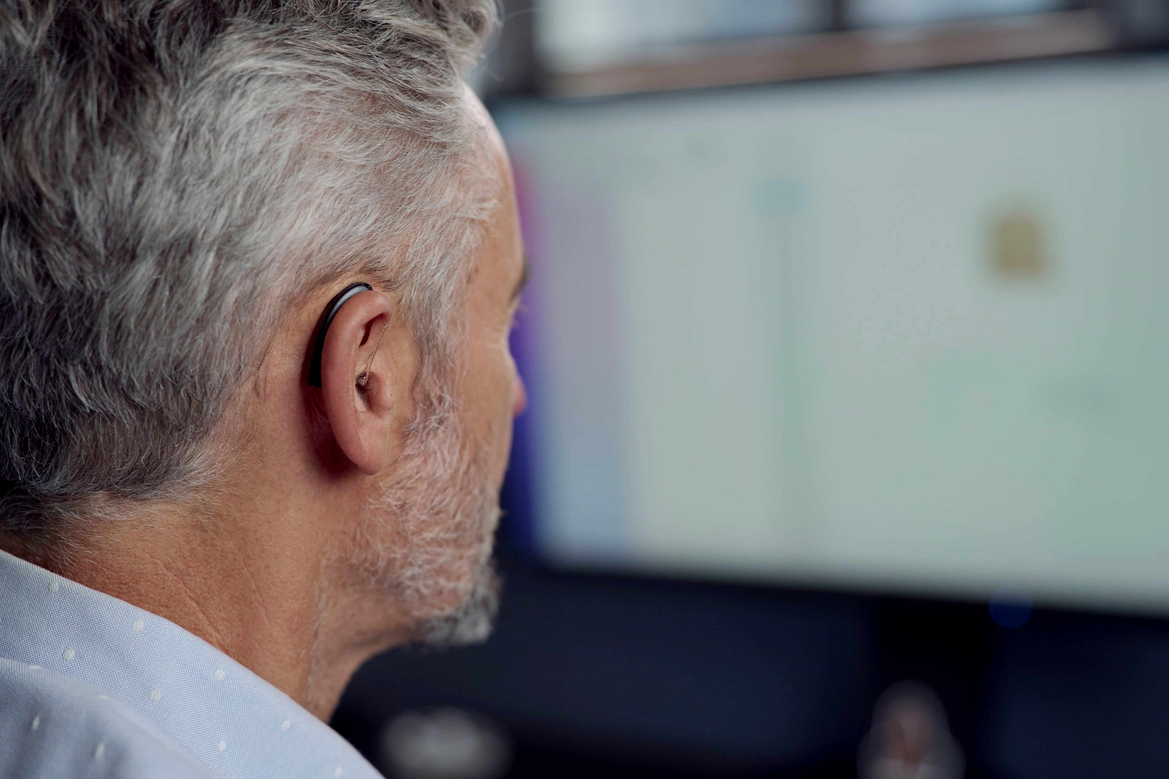 Mann mit Viennatone Art 8 Hörgerät hinter dem Ohr