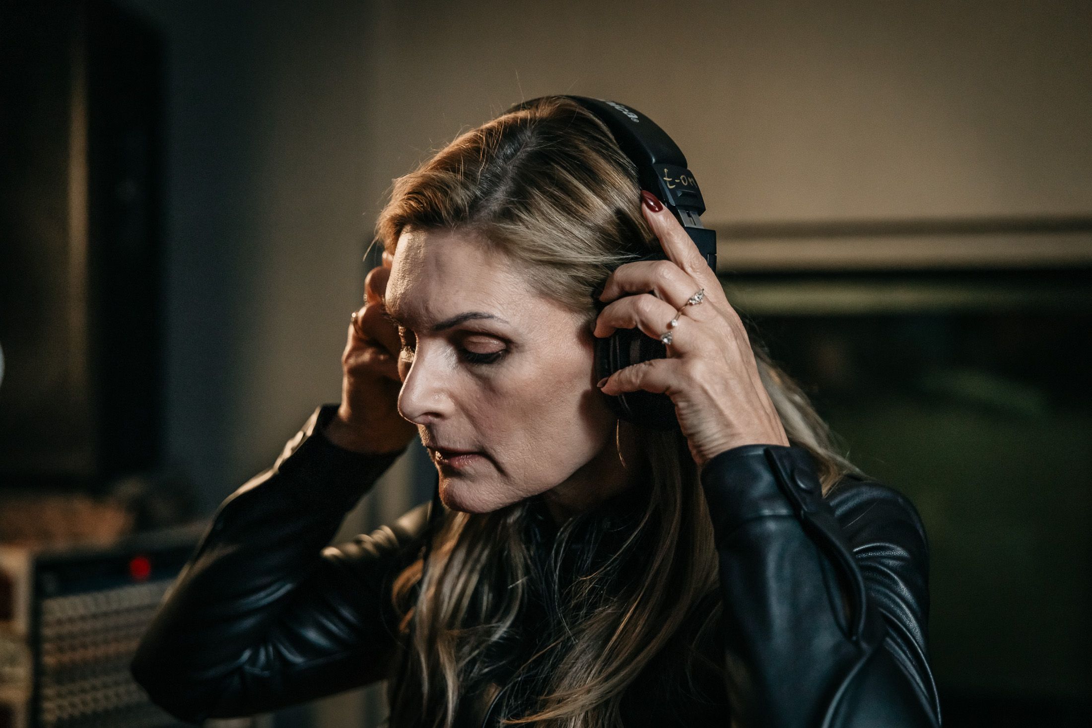 Martina Kaiser in Musikstudio. Setzt die Kopfhörer auf.