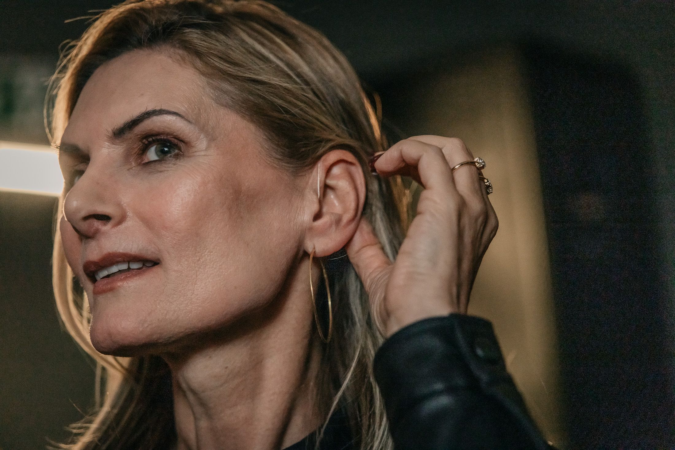 Matina Kaiser richtet ihre Haare und zeigt dabei das Hörgerät in ihrem Ohr.