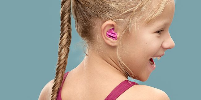 Nahaufnahme eines lachenden Mädchens im Badeanzug mit Earwear swim
