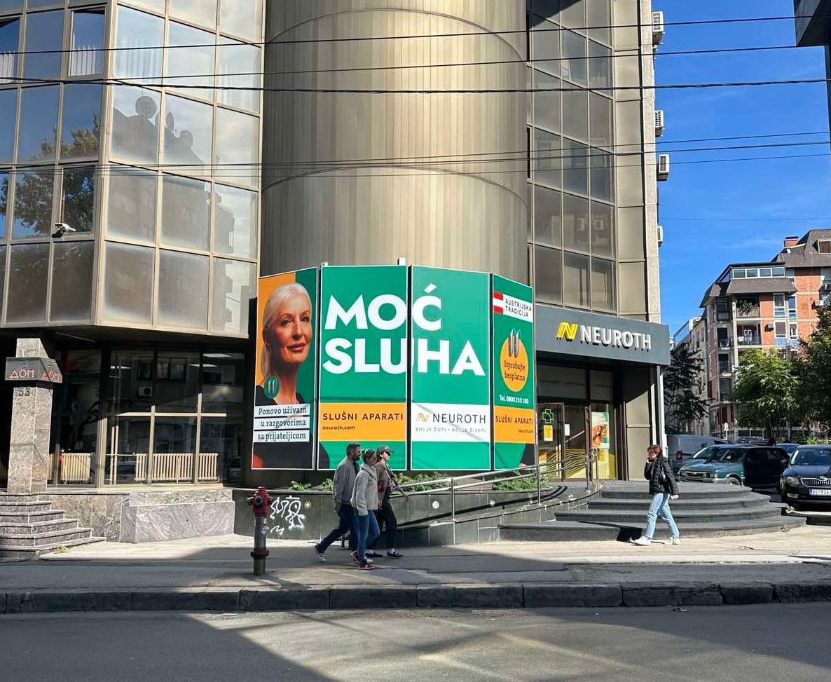 Slika ulaza Neuroth slusnog centra sa ulice sa plakatom Moc sluha pored
