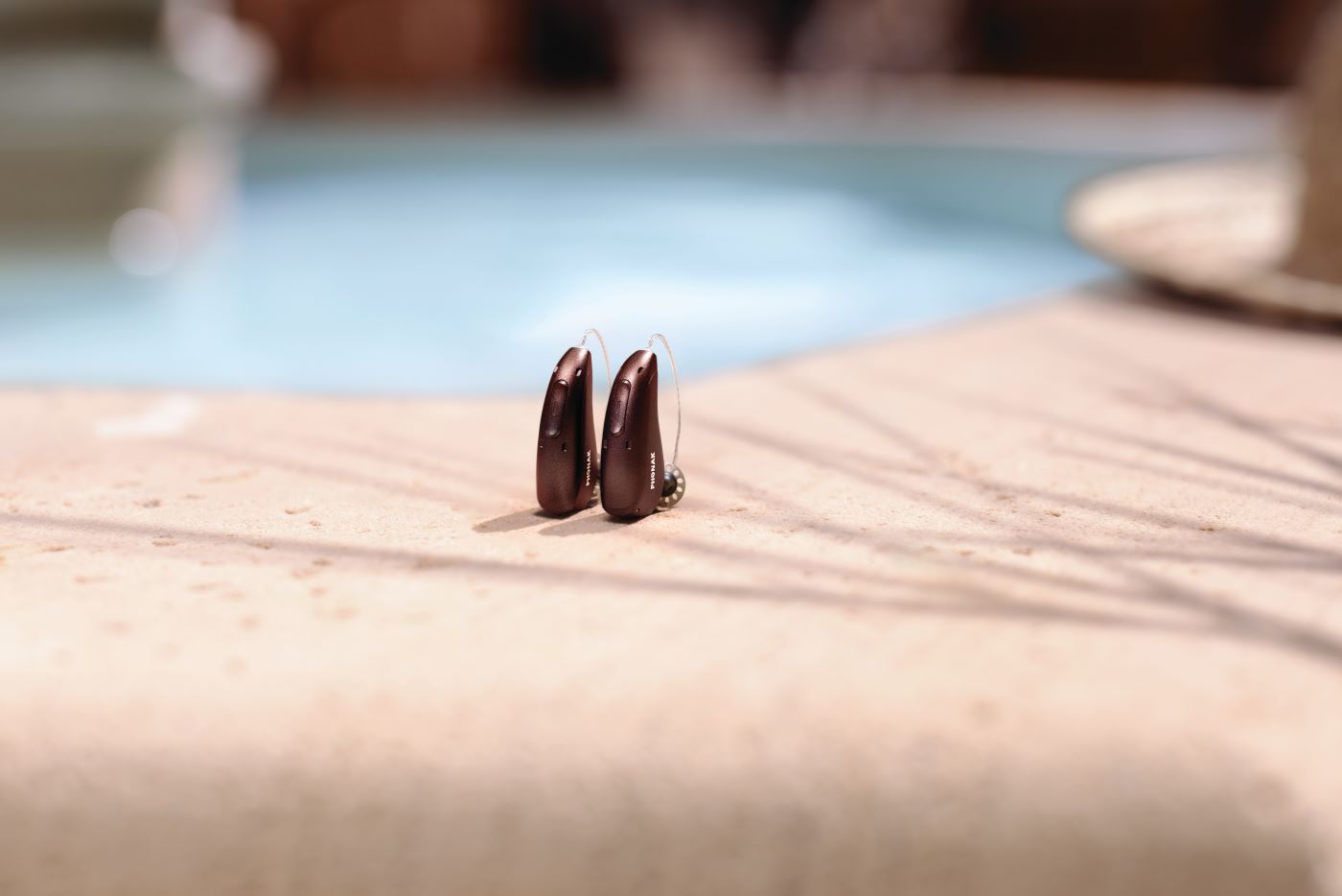 Phonak slusni aparati braon boje pored bazena