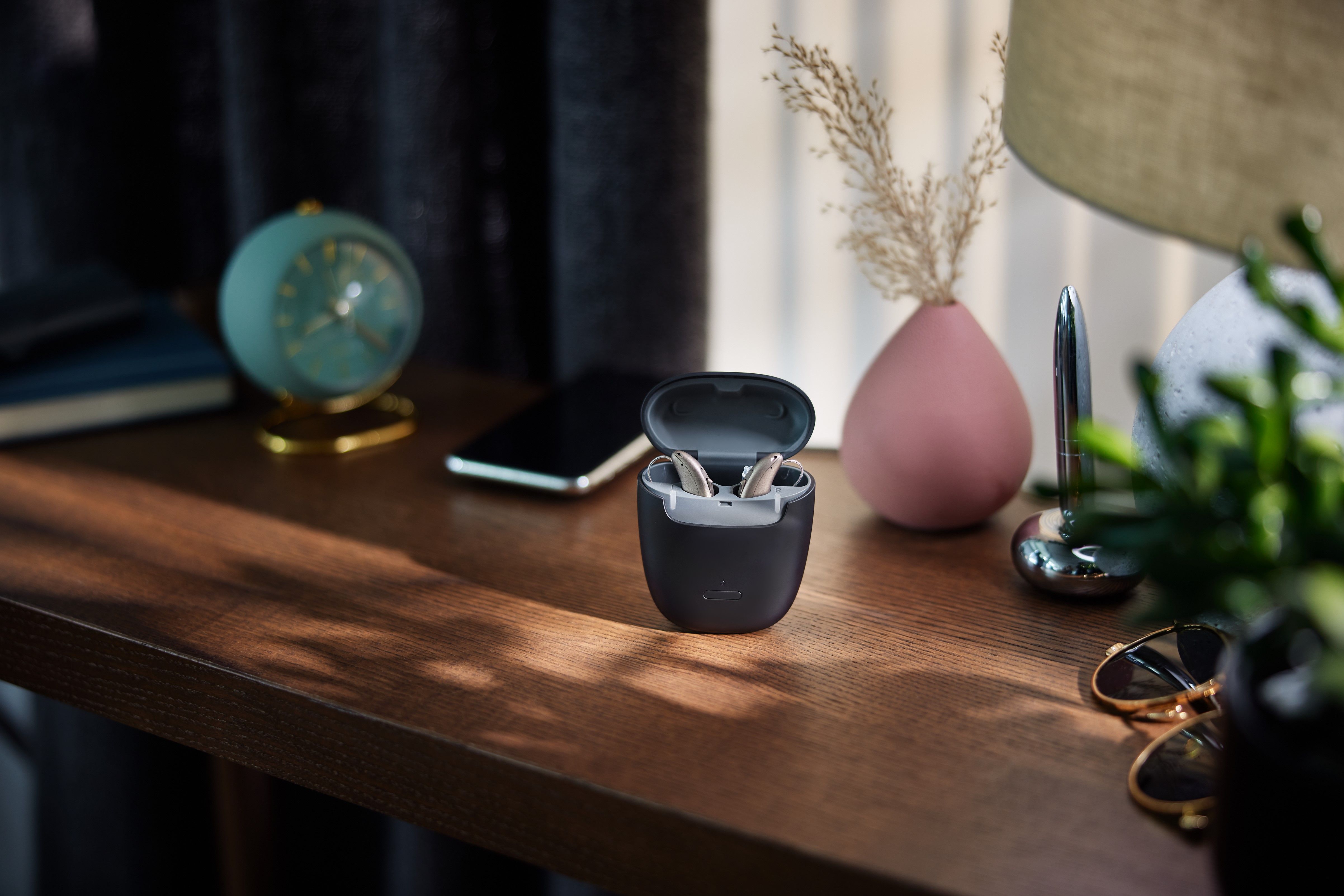 Viennatone Buzz 8 slušni aparati v polnilniku na leseni mizi