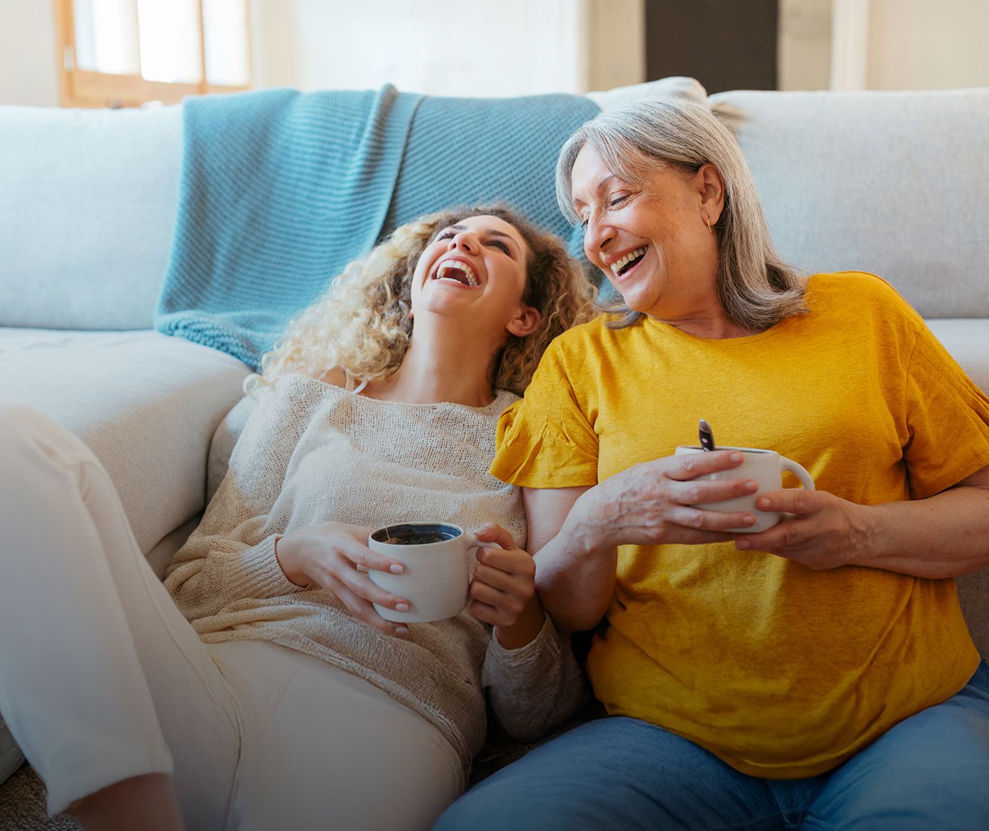 Zwei Frauen beim Kaffee lachen gemeinsam